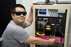 Физик из NIST Ичэн Ши с оборудованием, используемым для распределения запутанных фотонов
